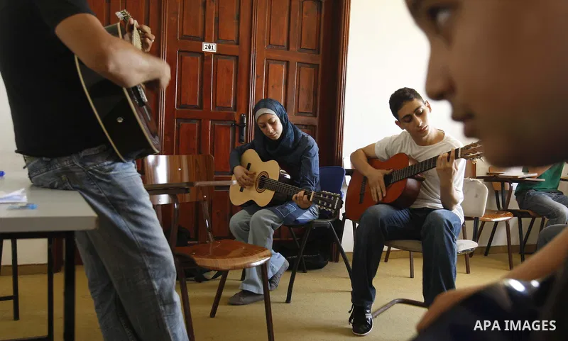 A Palestinian Music teacher during teaching students on on musical instruments at the Gaza College in the Department of Music in Gaza city on July 30, 2011. Photo by Mahmud Nassar