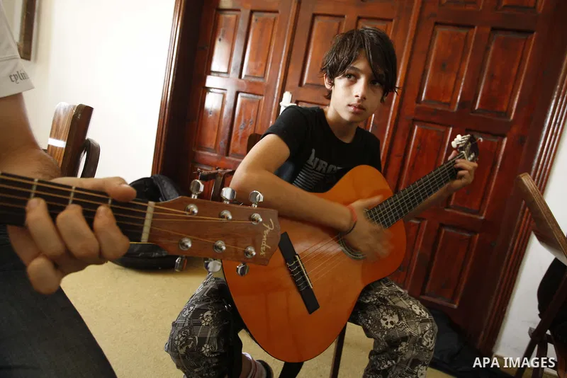 A Palestinian boy plays on musical instruments at the Gaza College in the Department of Music in Gaza city on July 30, 2011. Photo by Mahmud Nassar