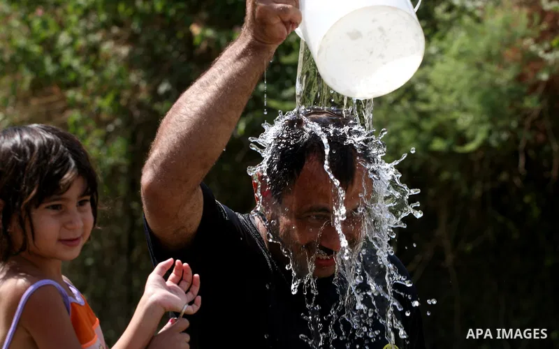 Palestinians immerse themselves in a running stream of channelled irrigation water as they cool off in the biblical city of Jericho where the temperatures soared to 47 degrees Celsius, on July 30, 2011. Photo by Issam Ri...