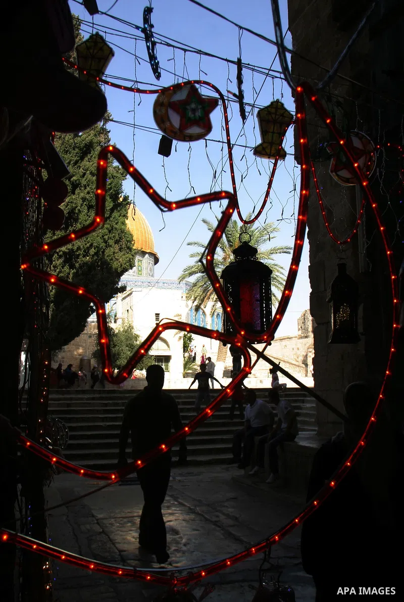 Palestinians walks under decorations ahead of the Muslim holy month of Ramadan in Jerusalem's Old City July 30, 2011. Muslims around the world abstain from eating, drinking and sexual relations from sunrise to sunset dur...