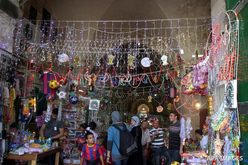 Palestinians walks under decorations ahead of the Muslim holy month of Ramadan in Jerusalem's Old City July 30, 2011. Muslims around the world abstain from eating, drinking and sexual relations from sunrise to sunset dur...