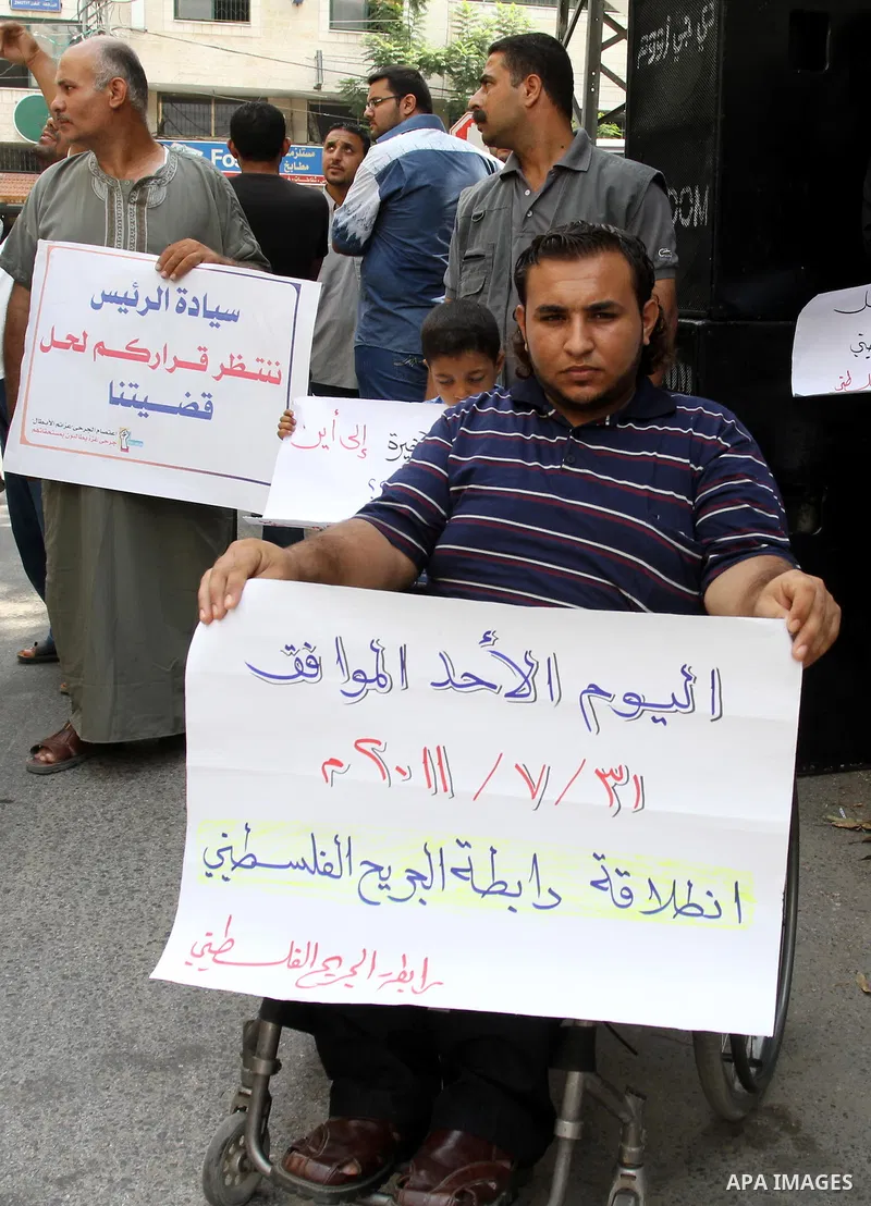 Palestinians wounded, take part in a protest demanding the authority of Ramallah to grant them their rights and entitlements in Gaza city on July 31, 2011. Photo by Mohammed Asad