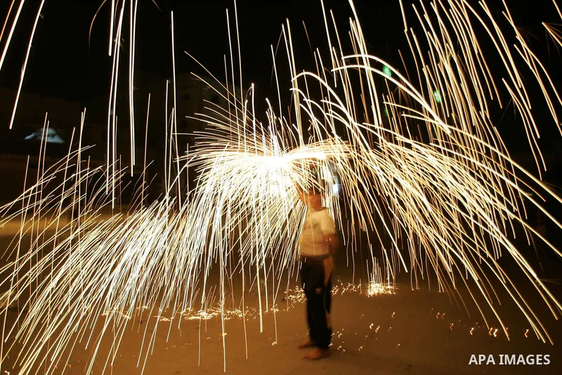 A Palestinian boy plays with fire crackers celebrating ahead of the Muslim holy month of Ramadan, in Rafah, southern Gaza Strip on July 30, 2011, where today is the complement of the month of Sha'ban, and tomorrow is the...