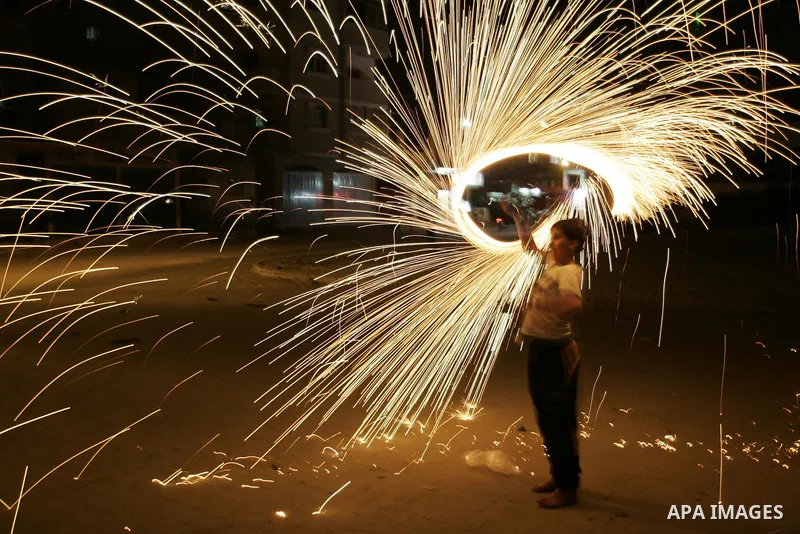 A Palestinian boy plays with fire crackers celebrating ahead of the Muslim holy month of Ramadan, in Rafah, southern Gaza Strip on July 30, 2011, where today is the complement of the month of Sha'ban, and tomorrow is the...