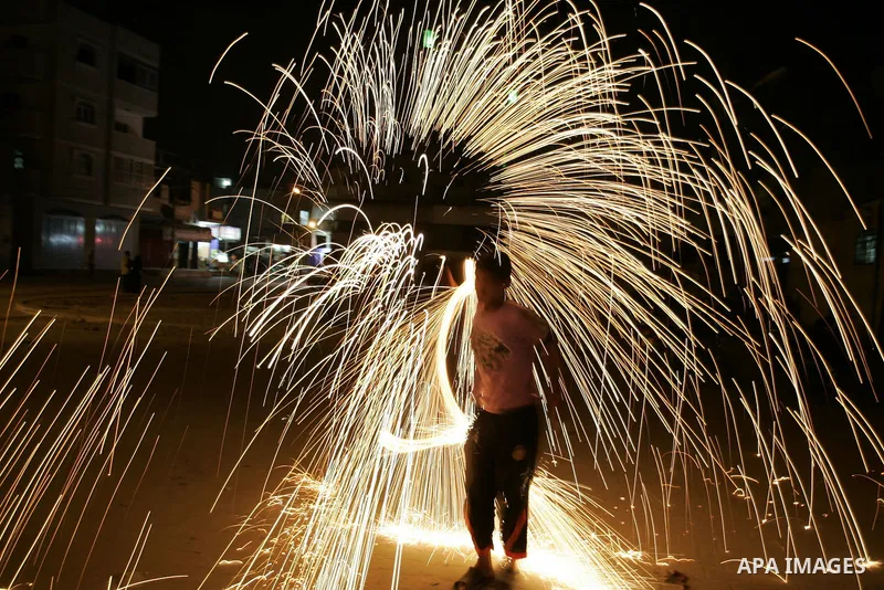 A Palestinian boy plays with fire crackers celebrating ahead of the Muslim holy month of Ramadan, in Rafah, southern Gaza Strip on July 30, 2011, where today is the complement of the month of Sha'ban, and tomorrow is the...