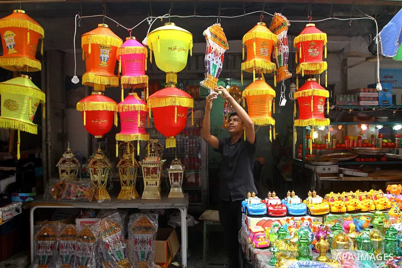 A Palestinian man hangs lanterns outside his shop ahead of the Muslim holy fasting month of Ramadan at Al-Zawiya market in Gaza City on July 31, 2011. Photo by Ashraf Amra