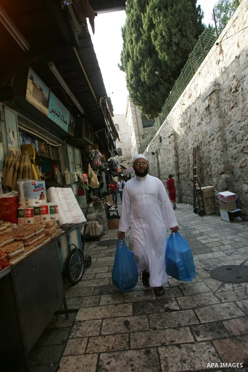 Palestinians are walk at the entrance of the Al-Aqsa mosque compound, in the old city of Jerusalem, on July 31 2011, as people ready for the upcoming Muslim holy fasting month of Ramadan. Photo by Mahfouz Abu Turk