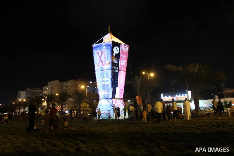Palestinians sit and walk around a giant lantern set to mark the Muslim holy fasting month of Ramadan on July 31, 2011 in Gaza City. Photo by Mohammed Asad