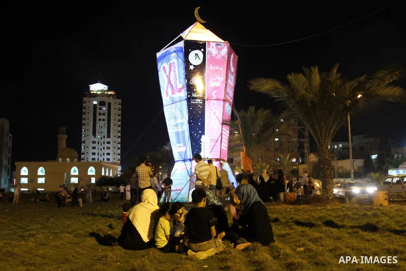 Palestinians sit and walk around a giant lantern set to mark the Muslim holy fasting month of Ramadan on July 31, 2011 in Gaza City. Photo by Mohammed Asad