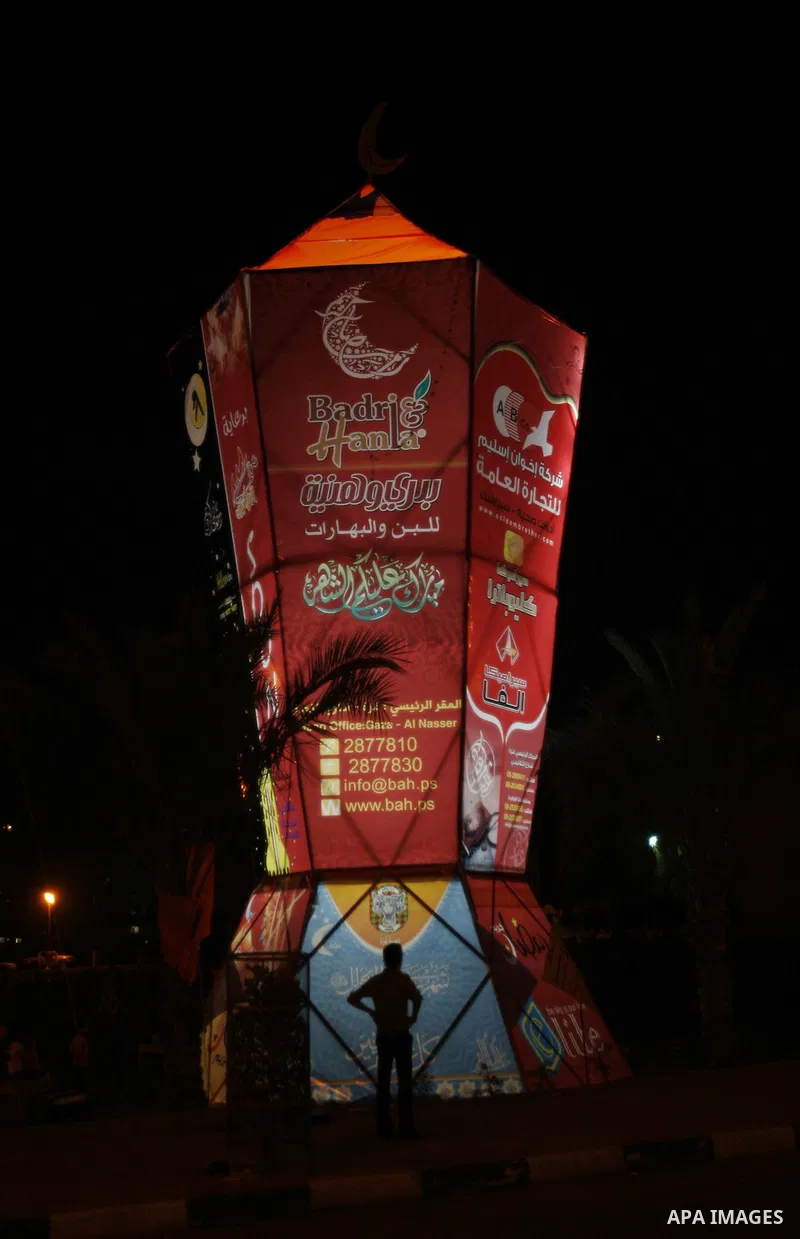Palestinians sit and walk around a giant lantern set to mark the Muslim holy fasting month of Ramadan on July 31, 2011 in Gaza City. Photo by Mahmud Nassar