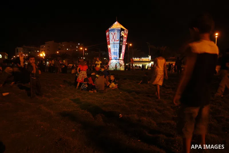 Palestinians sit and walk around a giant lantern set to mark the Muslim holy fasting month of Ramadan on July 31, 2011 in Gaza City. Photo by Mahmud Nassar