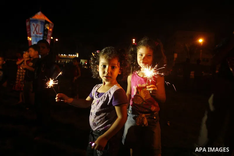 Palestinians sit and walk around a giant lantern set to mark the Muslim holy fasting month of Ramadan on July 31, 2011 in Gaza City. Photo by Mahmud Nassar