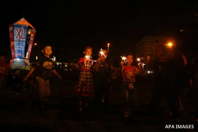 Palestinians sit and walk around a giant lantern set to mark the Muslim holy fasting month of Ramadan on July 31, 2011 in Gaza City. Photo by Mahmud Nassar