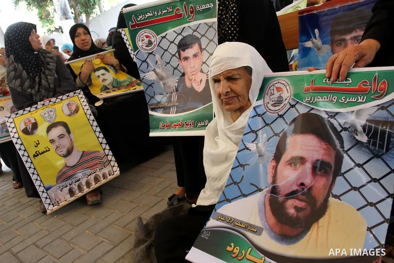 Palestinians women hold pictures of their prisoned relatives in Israeli jails as they gather in a weekly activity calling for their liberty at the Red Cross headquarters in Gaza City on Aug.1, 2011. About 7000 prisoners...