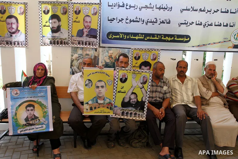 Palestinians women hold pictures of their prisoned relatives in Israeli jails as they gather in a weekly activity calling for their liberty at the Red Cross headquarters in Gaza City on Aug.1, 2011. About 7000 prisoners...