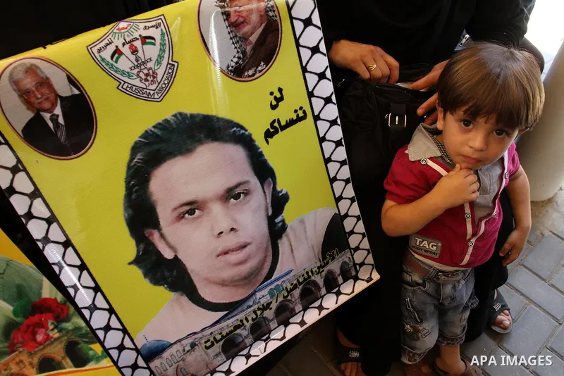 Palestinians hold pictures of their prisoned relatives in Israeli jails as they gather in a weekly activity calling for their liberty at the Red Cross headquarters in Gaza City on Aug.1, 2011. About 7000 prisoners are in...