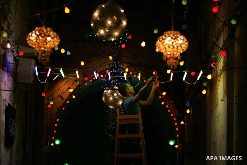 Palestinian men hang decorations for the upcoming holy month of Ramadan outside his home in Jerusalem's Old City July 31, 2011. Muslims around the world abstain from eating, drinking and conducting sexual relations from...