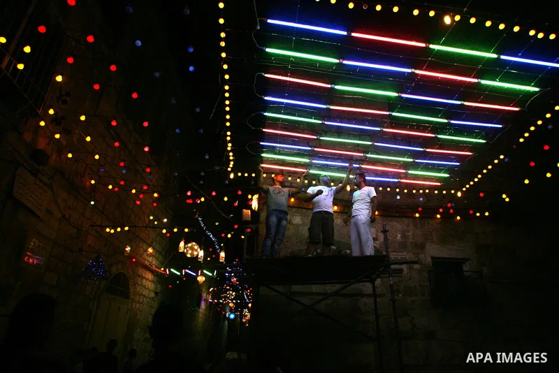 Palestinian men hang decorations for the upcoming holy month of Ramadan outside his home in Jerusalem's Old City July 31, 2011. Muslims around the world abstain from eating, drinking and conducting sexual relations from...