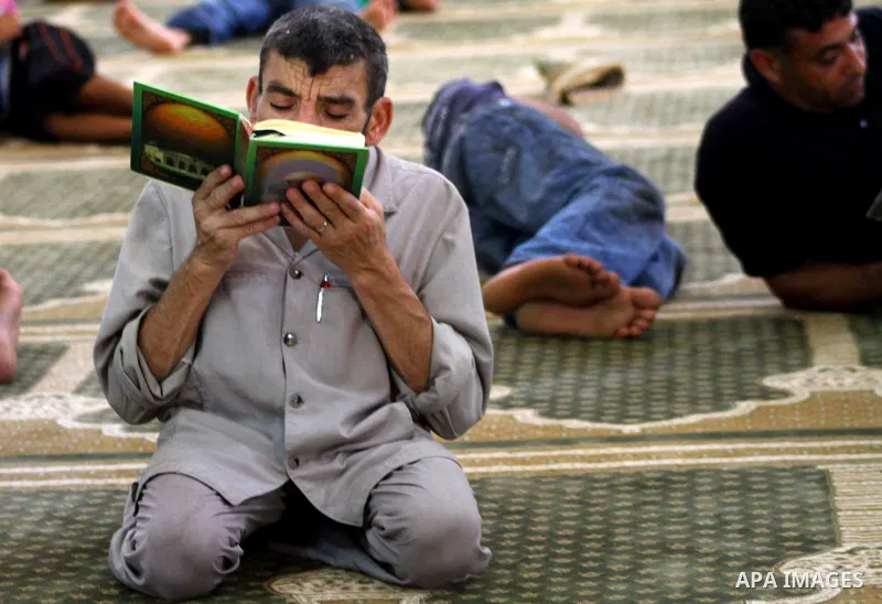 A Palestinian man reads the holy koran on the first day of holy fasting month of Ramadan at al-Omari mosque in Gaza city on Aug. 1, 2011. Throughout the holy month of Ramadan devout Muslims must abstain from food, drink...