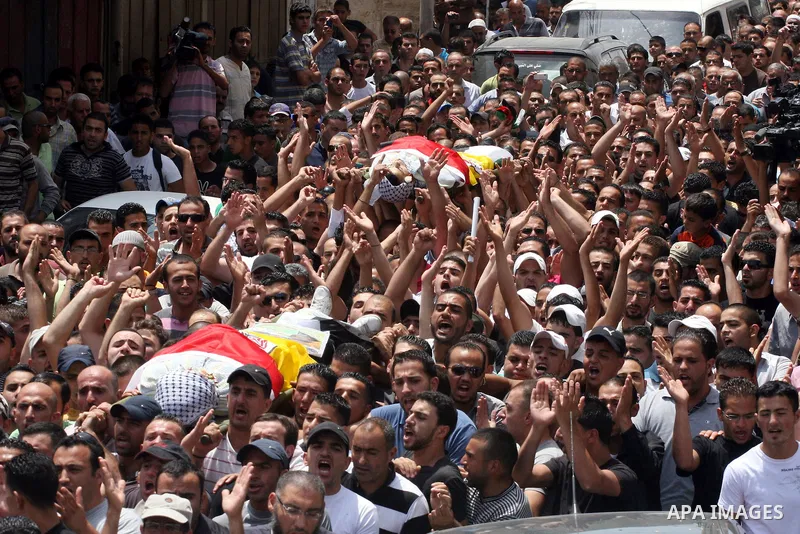 Palestinian mourners carry the bodies of Moatassem Adwan, 23, and Ali Khalifa, 22, during their funeral on August 1, 2011 after the two Palestinians were shot dead overnight by Israeli soldiers in the Qalandia refugee ca...