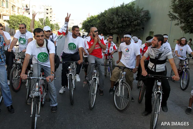 Members of the aid convoy 'Miles of Smiles 4' ride bicycles in a rally to express solidarity with Palestinian people after they entered Gaza through the Rafah border crossing between Egypt and southern Gaza Strip, on Aug...