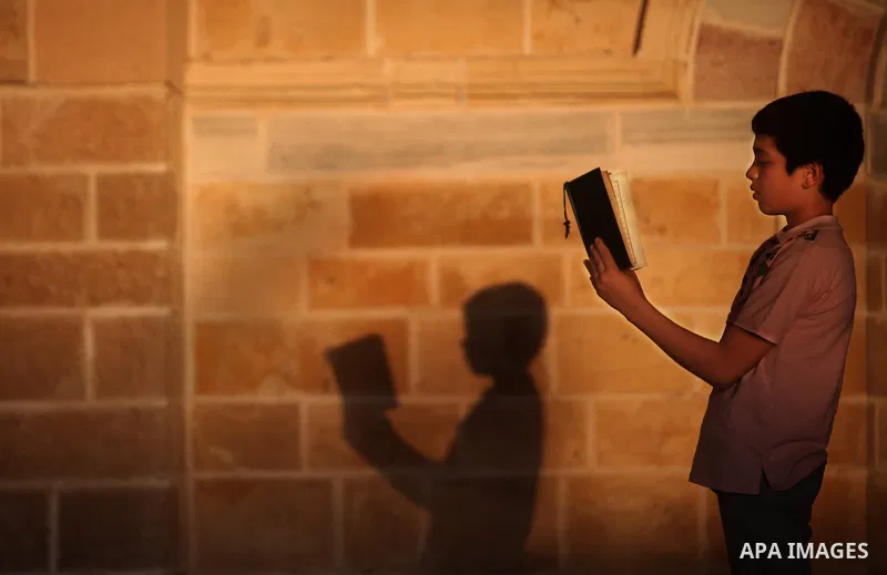 Palestinian boys read the Koran at the al-Omari mosque in Gaza City on the first day of the Muslim holy fasting month of Ramadan on 01 August 2011. Muslims throughout the world are celebrating the holy fasting month of R...