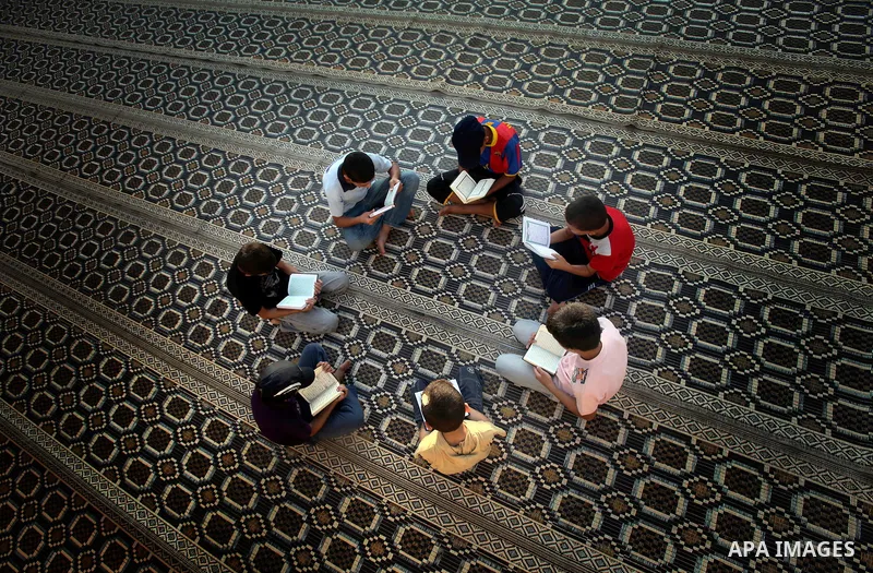 Palestinian boys read the Koran at the al-Omari mosque in Gaza City on the first day of the Muslim holy fasting month of Ramadan on 01 August 2011. Muslims throughout the world are celebrating the holy fasting month of R...