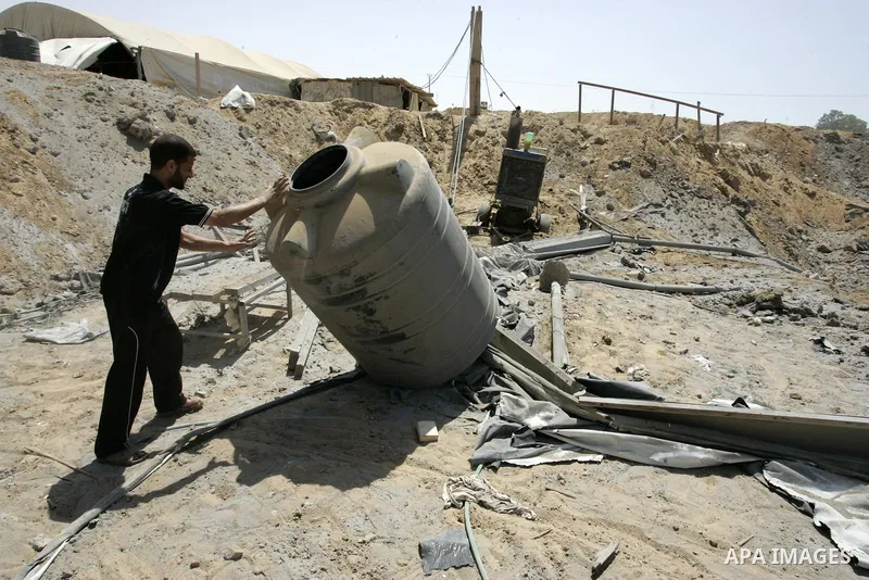A Palestinians man inspects the damage outside a smuggling tunnel following an overnight Israeli airstrike in Rafah, on the border between Egypt and southern Gaza Strip, Tuesday, Aug 2, 2011. Israel bombed the tunnel in...