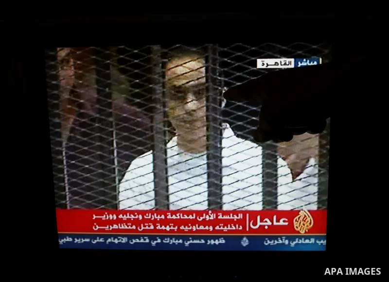 This video image taken from Egyptian State Television shows the sons of Hosni Mubarak stand inside the cage of mesh and iron bars in a Cairo courtroom Wednesday Aug. 3, 2011 as his historic trial began on charges of corr...