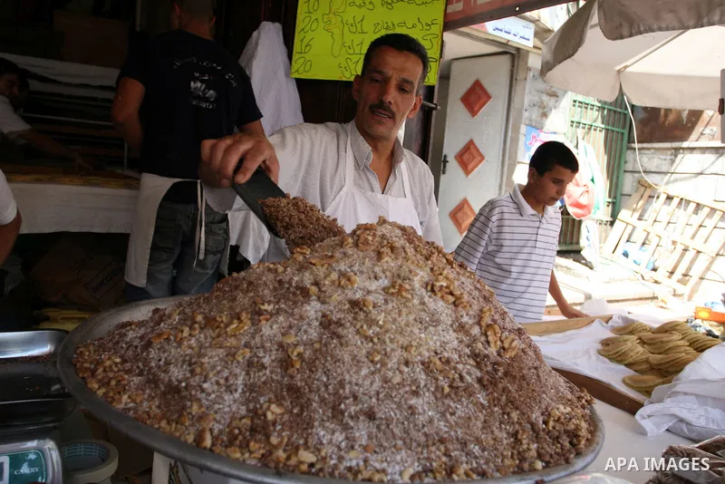 A Palestinian vendor during equipping the pistachio used for the traditional Qatayef on a fasting day of Ramadan in the West Bank city of Ramallah, on Aug. 3, 2011. Muslims around the world abstain from eating, drinking...