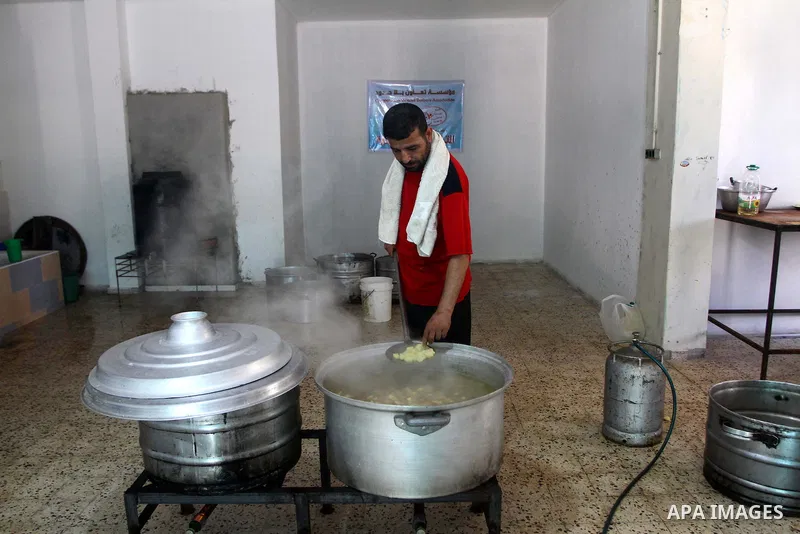 Palestinian bakers prepare meat and rice " free food" for 'Iftar', at charity in Gaza city on Aug. 3, 2011. where provides a free meal all the year round to poor Muslims during the holy fasting month of Ramadan, when obs...