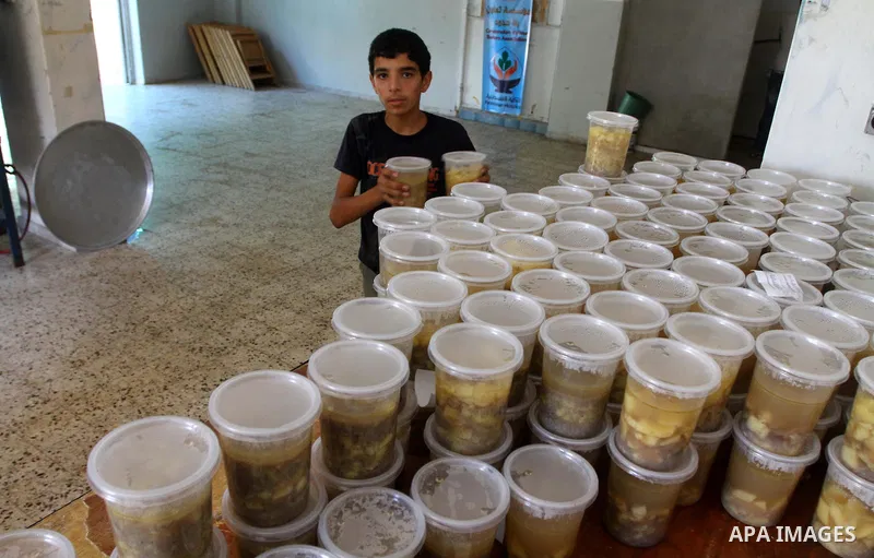 A Palestinian boy encases the meal " free food" for 'Iftar', at charity in Gaza city on Aug. 3, 2011. where provides a free meal all the year round to poor Muslims during the holy fasting month of Ramadan, when observant...