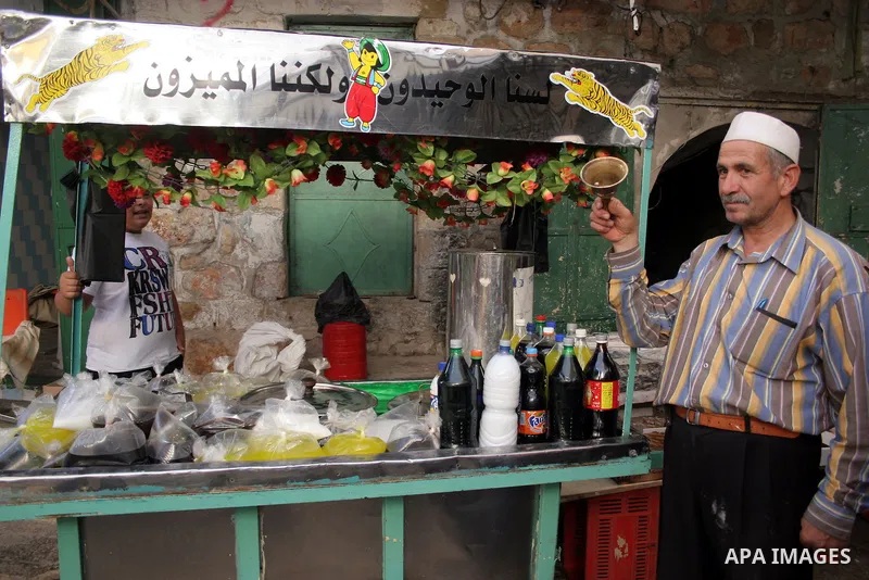 A Palestinian vendor sells juice "kharroub" at a market in the West Bank city of Hebron August 3, 2011. Muslims around the world abstain from eating, drinking and conducting sexual relations from sunrise to sunset during...