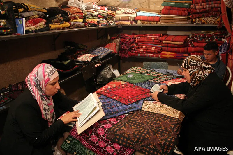 Palestinian women read the holy koran at a shop in the West Bank city of Hebron August 3, 2011. Muslims around the world abstain from eating, drinking and conducting sexual relations from sunrise to sunset during Ramadan...