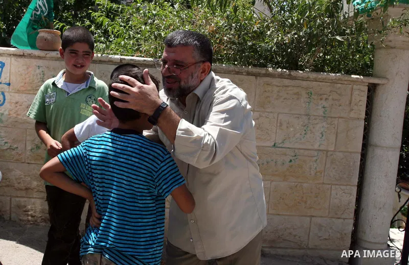 A Palestinian commander of the Hamas Islamist movement, Sheikh Hassan Yusef, 56, hugs his son in his home in the West Bank city of Ramallah after he was released from an Israeli jails, on Aug. 4, 2011. as Israel free 770...