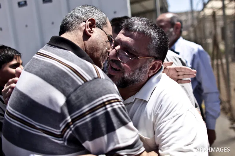A Palestinian commander of the Hamas Islamist movement, Sheikh Hassan Yusef, 56, hugs his relatives in his home in the West Bank city of Ramallah after he was released from an Israeli jails, on Aug. 4, 2011. as Israel fr...