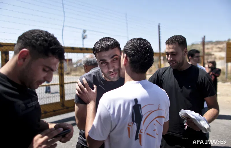 Palestinian prisoners seen crossing the border after they were released from Israeli prison, at the checkpoint of Betwnia next to the Israeli Military prison of Ofer, south of the West Bank town of Ramallah, 04 August 20...