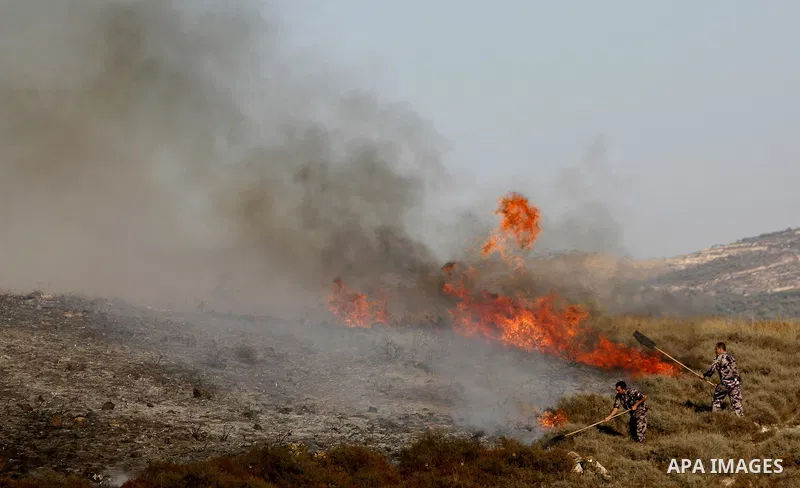 Israeli settlers hurl rocks at Palestinians, not seen, on the outskirts of Burin village, near the Jewish settlement burning fields on Palestinian land close to the village of Burin, near the West Bank town of Nablus, on...