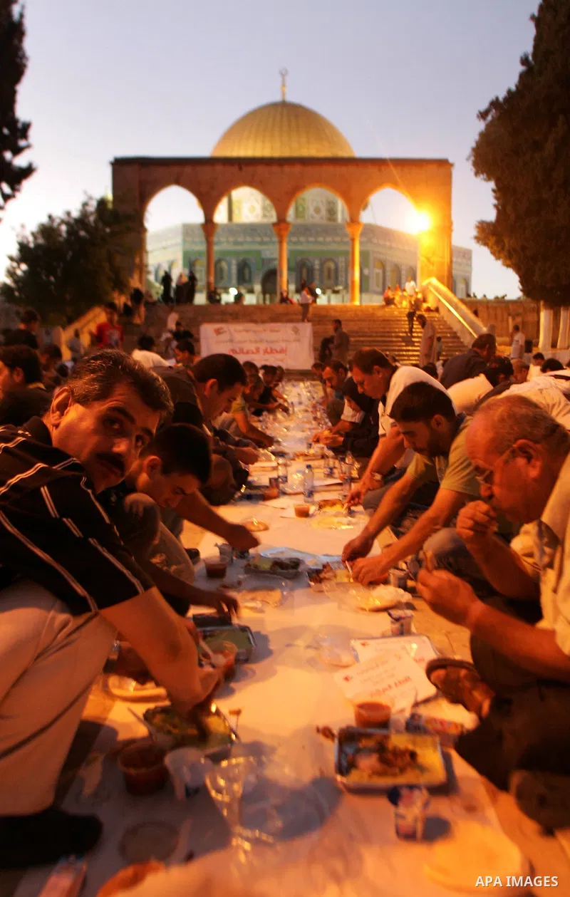 Muslim Palestinians break their fast in the courtyard of Jerusalem's Al-Aqsa mosque, Islam's third holiest shrine, on August 4, 2010 during a group charity iftar meal on the fourth day of the holy month of Ramadan. Photo...