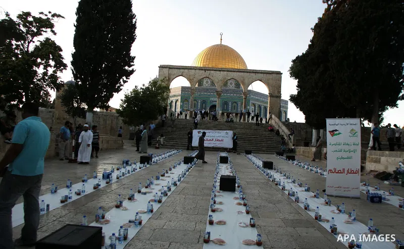 Muslim Palestinians wait to receive their iftar meals donated by a charity in the courtyard of Jerusalem's Al-Aqsa mosque, Islam's third holiest shrine, just before sunset on August 4, 2010. Iftar is the evening meal wit...