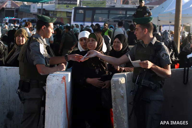 Israeli border policemen check the IDs of Palestinian worshippers as they waiting in line to pass at Qalandia checkpoint that leads from the West Bank town of Ramallah to Jerusalem on Aug. 5, 2011, in order to attend the...