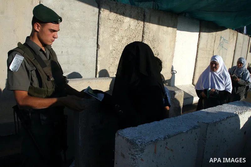 Israeli border policemen check the IDs of Palestinian worshippers as they waiting in line to pass at Qalandia checkpoint that leads from the West Bank town of Ramallah to Jerusalem on Aug. 5, 2011, in order to attend the...
