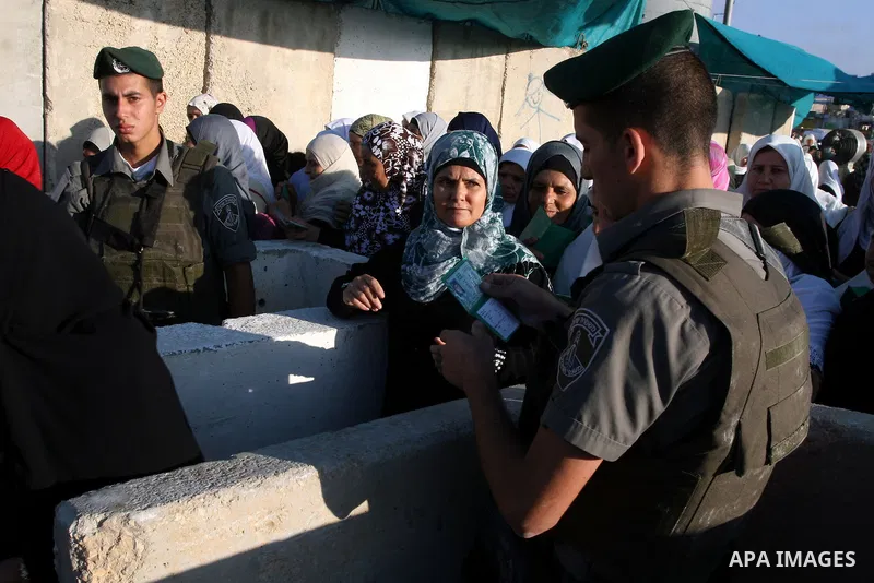 Israeli border policemen check the IDs of Palestinian worshippers as they waiting in line to pass at Qalandia checkpoint that leads from the West Bank town of Ramallah to Jerusalem on Aug. 5, 2011, in order to attend the...