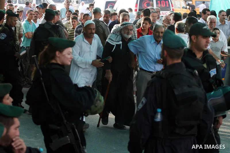Palestinian Muslims walk towards the Israeli checkpoint of Qalandiya near the West Bank city of Ramallah on Aug. 5, 2011, before crossing into Jerusalem to attend the first Friday prayers of the holy month of Ramadan at...