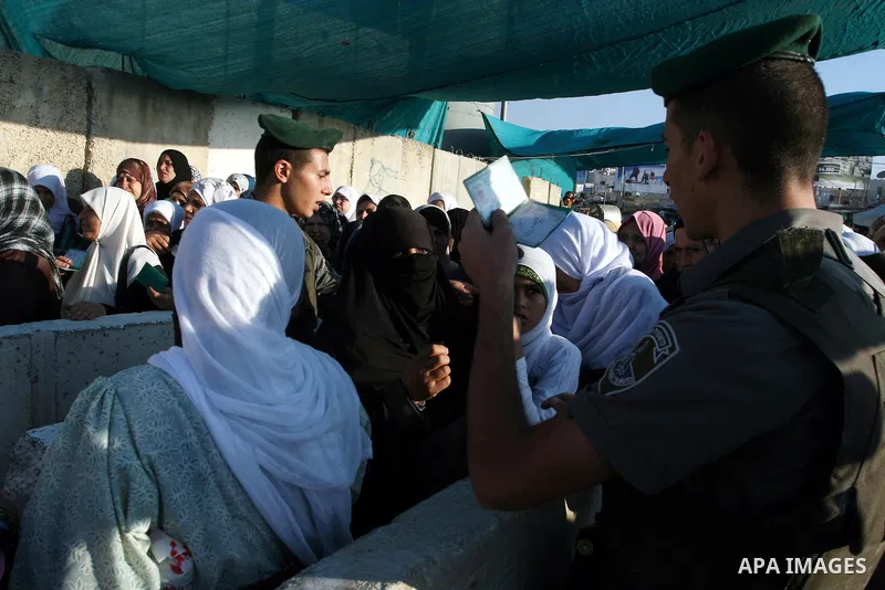 Israeli border policemen check the IDs of Palestinian worshippers as they waiting in line to pass at Qalandia checkpoint that leads from the West Bank town of Ramallah to Jerusalem on Aug. 5, 2011, in order to attend the...