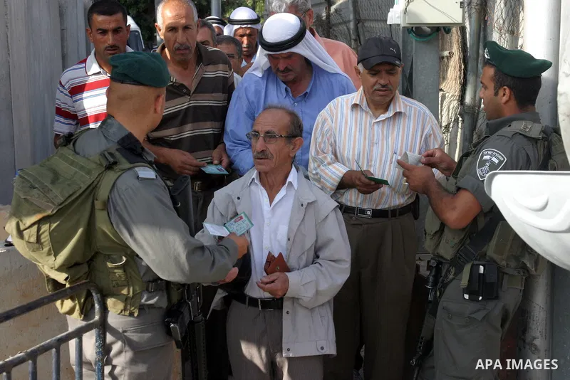 Israeli border policemen check the IDs of Palestinian worshippers as they waiting in line to pass at Qalandia checkpoint that leads from the West Bank town of Ramallah to Jerusalem on Aug. 5, 2011, in order to attend the...
