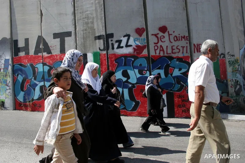 Palestinians walk in line to cross from the Qalandia checkpoint that leads from the West Bank town of Ramallah to Jerusalem on 05 August 2011, in order to attend the Friday prayers in the holy Muslim month of Ramadan at...