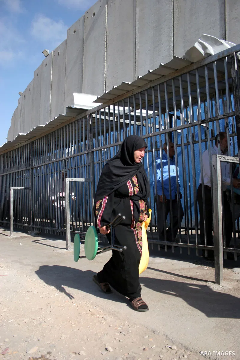 Palestinians walk in line to cross from the Qalandia checkpoint that leads from the West Bank town of Ramallah to Jerusalem on 05 August 2011, in order to attend the Friday prayers in the holy Muslim month of Ramadan at...