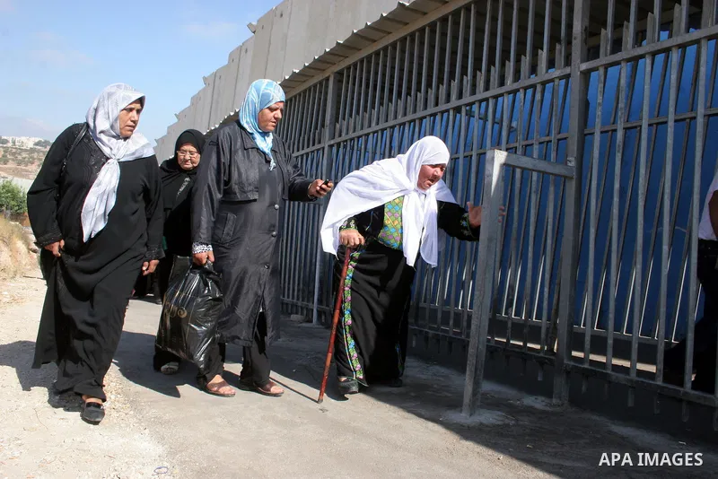 Palestinian women walk in line to cross from the Qalandia checkpoint that leads from the West Bank town of Ramallah to Jerusalem on 05 August 2011, in order to attend the Friday prayers in the holy Muslim month of Ramada...