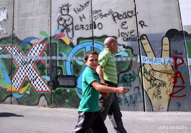 Palestinians walk in line to cross from the Qalandia checkpoint that leads from the West Bank town of Ramallah to Jerusalem on 05 August 2011, in order to attend the Friday prayers in the holy Muslim month of Ramadan at...
